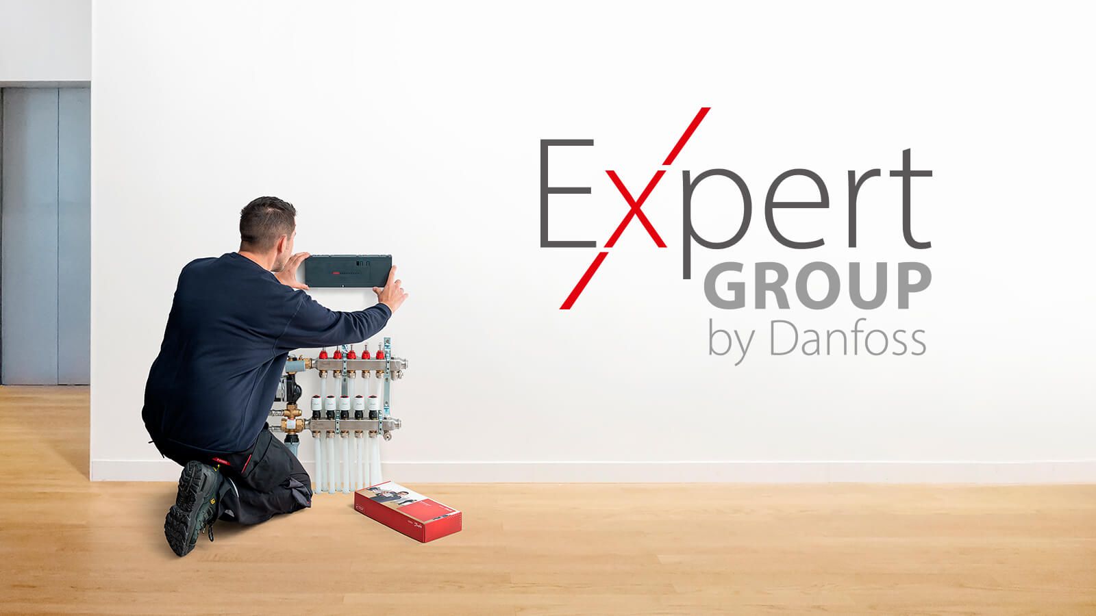 Installateur montiert Danfoss Heizkreisverteiler-Steuerung – Logo «Expert Group by Danfoss»