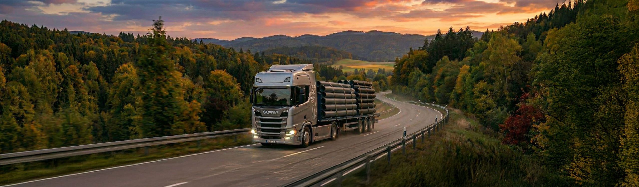 Spaeter AG Liefertransport – Sattelschlepper mit Kunststoffrohren auf einer Landstrasse bei Sonnenuntergang